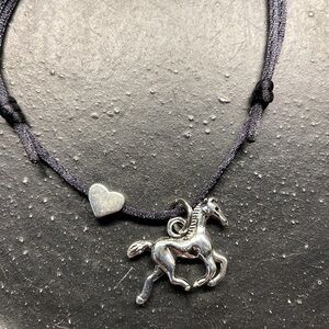 Adjustable cord bracelet with horse charm and heart.